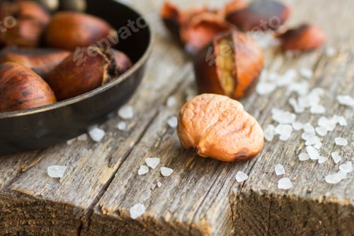 Preview: Roasted Chestnuts On Wooden Table With Coarse Salt
