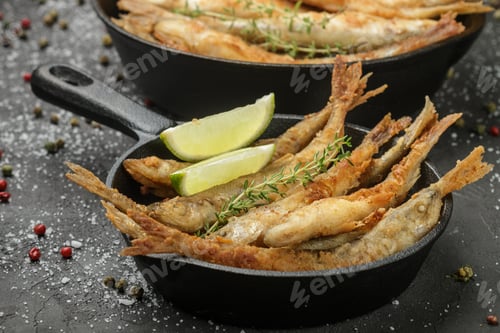 Preview: Fried Smelt In A Frying Pan On The Table With Spices, Lime And Thyme. Small Crispy Fish. Selective