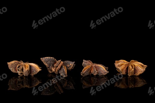 Preview: Group Of Four Whole Aromatic Brown Badian Isolated On Black Glass