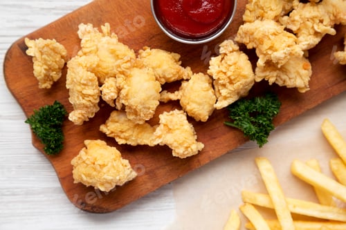 Preview: Homemade Popcorn Chicken On A Rustic Wooden Board On A White Wooden Background, Top View. Flat Lay