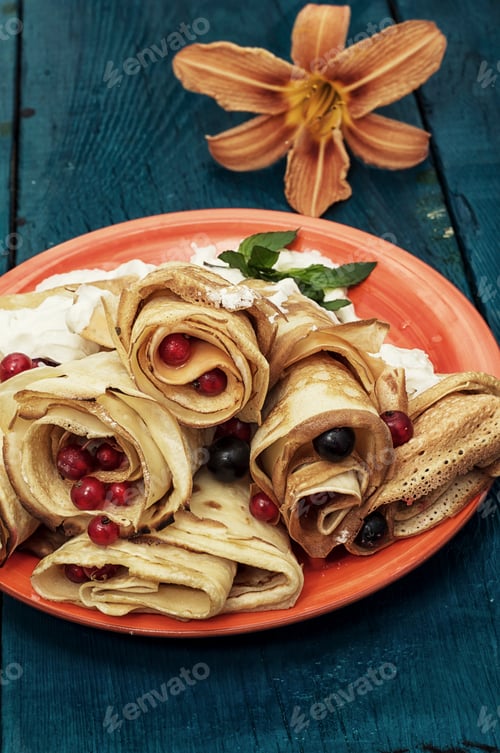 Rolled Crepes with Berries and Cream on Plate