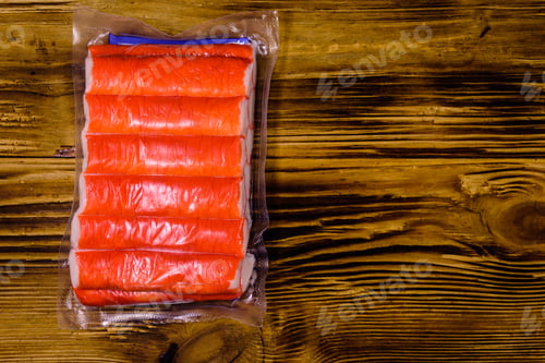 Preview: Vacuum Pack Of Crab Sticks On Wooden Table. Top View