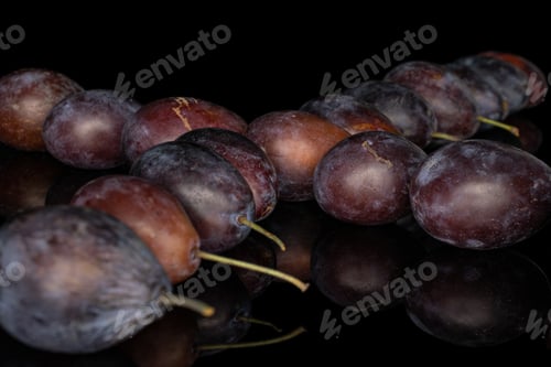 Preview: Lot Of Whole Crossed Sweet Purple Plum Isolated On Black Glass