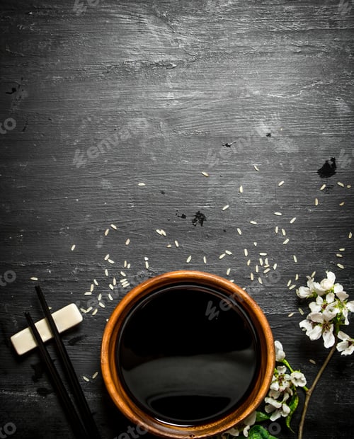 Preview: Soy Sauce And Branches Of Cherry Blossoms. On A Black Wooden Background.