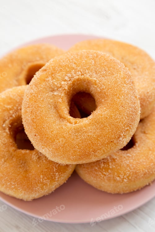 Preview: Homemade Autumn Apple-Cinnamon Donuts On A Pink Plate On A White Wooden Background, Low Angle View