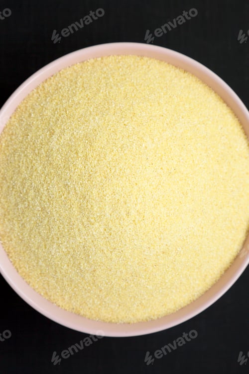 Preview: Dry Semolina Durum Flour In A Pink Bowl Over Black Background, View From Above. Top View, Overhead