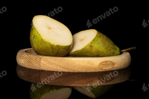 Preview: Group Of Two Halves Of Fresh Green Pear Conference On Bamboo Plate Isolated On Black Glass