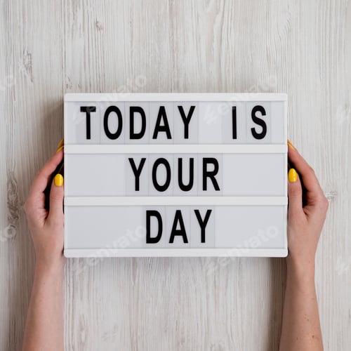Preview: Female Hands Hold Modern Board 'Today Is Your Day' Words Over White Wooden Background, Top View