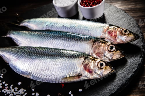 Preview: Fresh Raw Herrings Served On Black Stone On Wooden Table