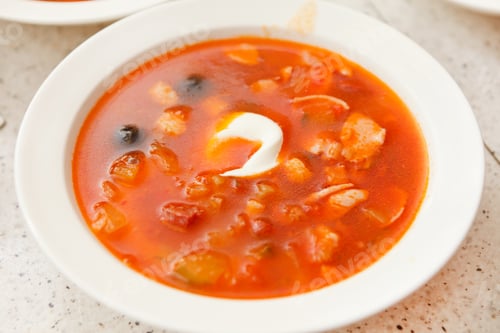 Preview: Hearty Red Soup with Cream in a White Bowl