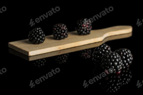 Preview: Blackberries on wooden board reflecting on black surface