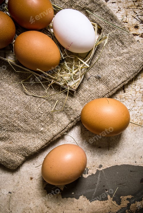 Preview: Eggs On The Old Bag And On The Hay. On Rustic Background.
