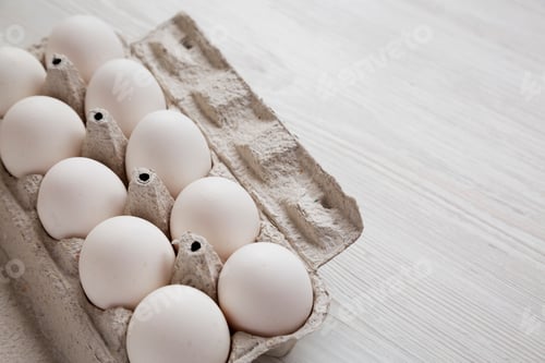 Preview: Uncooked Organic White Eggs In A Paper Box On A White Wooden Surface, Side View. Copy Space.