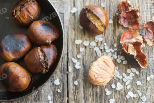 Preview: Roasted Chestnuts On Wooden Table With Coarse Salt
