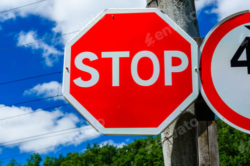 Preview: Stop Sign On Post At Roadside Against Blue Sky
