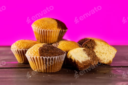 Preview: Group Of Four Whole Two Halves Of Fresh Baked Marble Muffin With Pink In Background