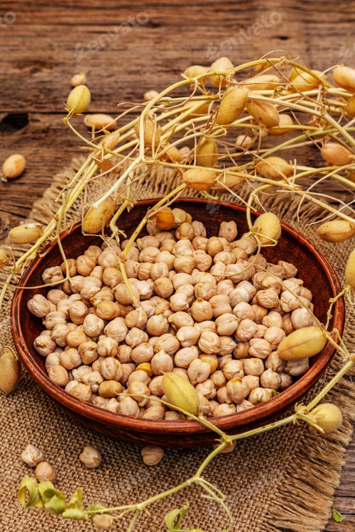 Preview: Dry Chickpea In Ceramic Bowl And It'S Own Branches On Old Wooden Boards Background. Traditional