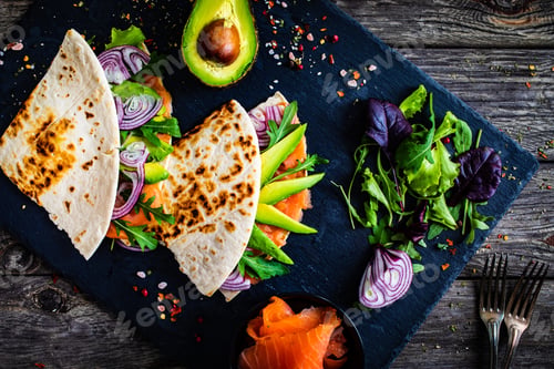 Preview: Italian Piada Wraps - Piada Stuffed With Smoked Salmon, Avocado, Arugula And Onion On Black Stone