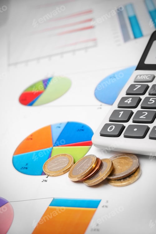 Preview: Calculator, Coins, and Charts on a White Surface