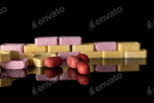 Preview: Lot Of Whole Sweet Pastel Candy Wall Isolated On Black Glass