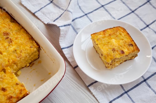 Preview: Homemade Cheesy Amish Breakfast Casserole On A White Wooden Surface, Low Angle View. Close-Up.