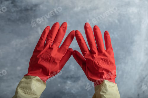 Preview: Female Hand In Red Protective Gloves On Marble Background