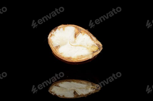 Preview: One Half Of Edible Brown Chestnut Isolated On Black Glass