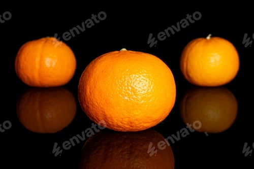 Preview: Group Of Three Whole Fresh Orange Mandarine Isolated On Black Glass