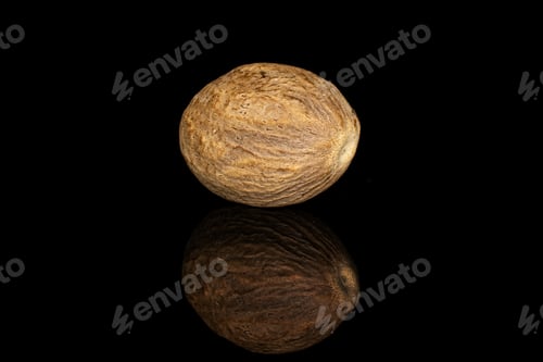 Preview: One Whole Dry Brown Nutmeg Isolated On Black Glass
