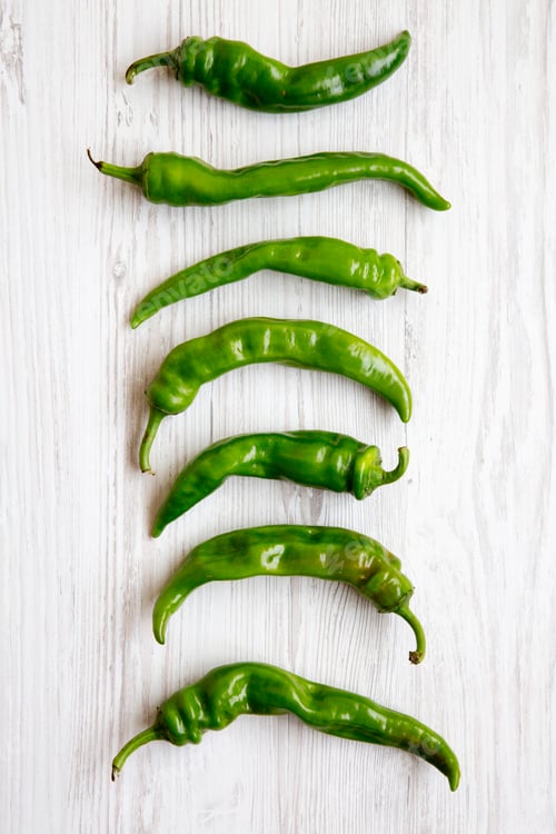 Preview: Green Chili Peppers On White Wooden Table, Overhead View. Flat Lay, From Above.