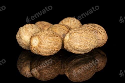 Preview: Group Of Seven Whole Dry Brown Nutmeg Isolated On Black Glass