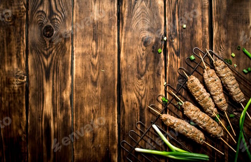 Preview: Kebab On The Grill With Green Onions. On A Wooden Table.
