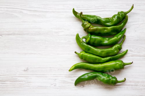 Preview: Green Chili Peppers On White Wooden Background, Top View. Flat Lay, From Above, Overhead. Copy