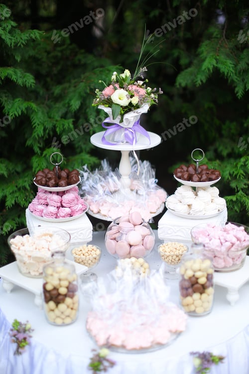 Preview: White Table With Sweets And Tasty Food In Green Background. Concept Of Wedding Cakes.