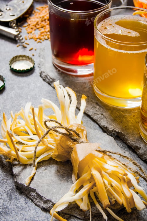 Preview: Glass Of Beer And Salty Cheese On A Stone Background.