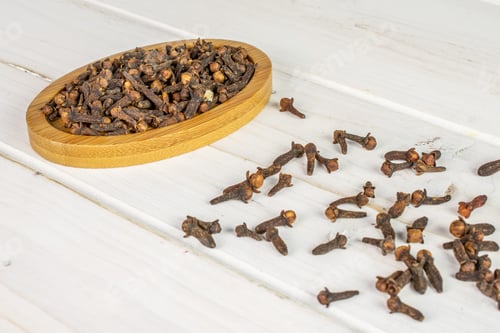 Preview: Lot Of Whole Dry Brown Clove On Bamboo Coaster On White Wood