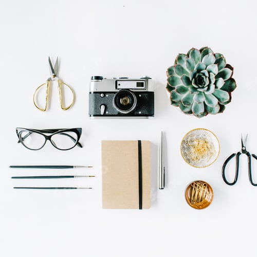 Preview: Feminine Desk Workspace With Succulent, Retro Camera, Scissors, Diary, Glasses And Golden Clips On