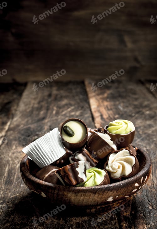 Preview: Chocolate Candies In A Bowl. On A Wooden Background.