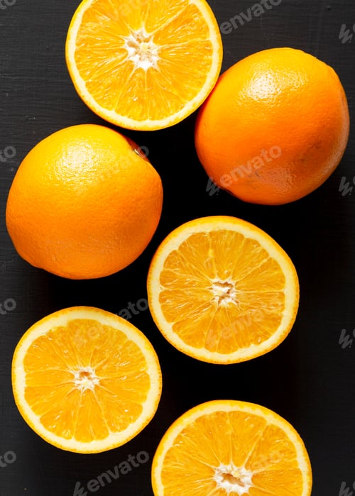 Preview: Top View, Halved And Whole Oranges Over Black Background. Overhead, From Above, Flat Lay. Close-Up.