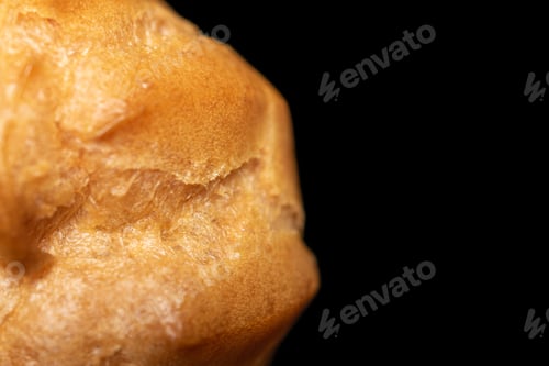 Preview: One Whole Baked Golden Profiterole Closeup Isolated On Black Glass
