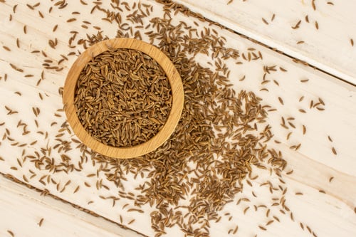 Preview: Lot Of Whole Small Dry Caraway Fruits In A Wooden Bowl Flatlay On White Wood