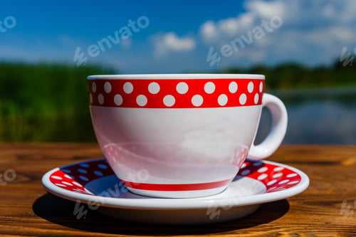 Preview: Cup Of Coffee On Rustic Wooden Table At The Riverside