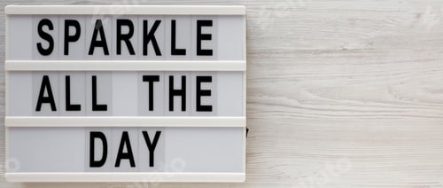 Preview: 'Sparkle All The Day' Words On A Modern Board On A White Wooden Surface, Top View. Overhead, From