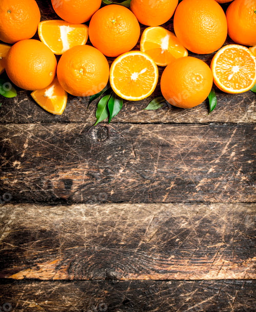 Preview: Fresh Oranges With Green Leaves. On Wooden Background.