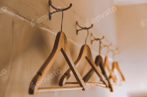 Preview: Row Of Empty Wooden Coat Hangers On The Wall In The Dressing Room. Close Up
