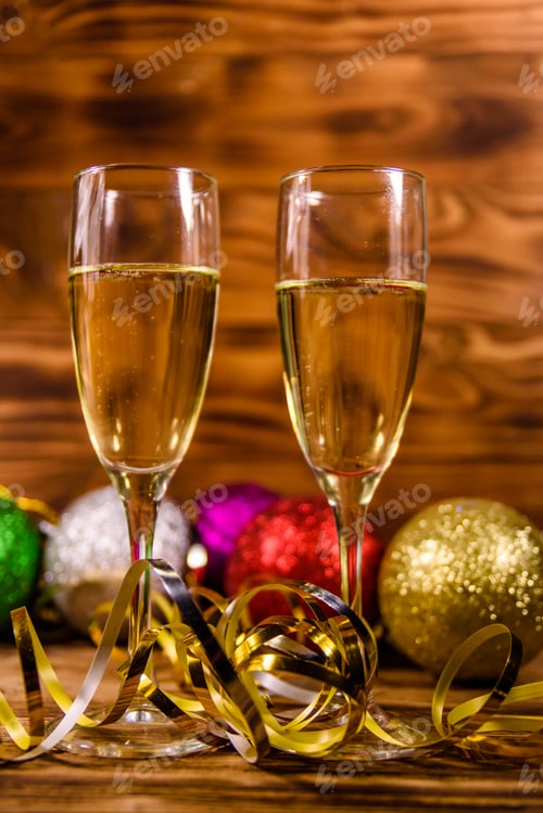 Preview: Two Wineglasses With Champagne And Different Christmas Decorations On Rustic Wooden Table