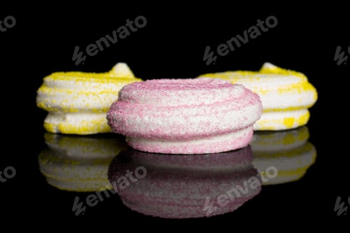 Preview: Group Of Three Whole Pink And Yellow Sweet Meringue Isolated On Black Glass