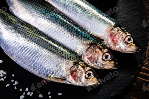 Preview: Fresh Raw Herrings Served On Black Stone On Wooden Table