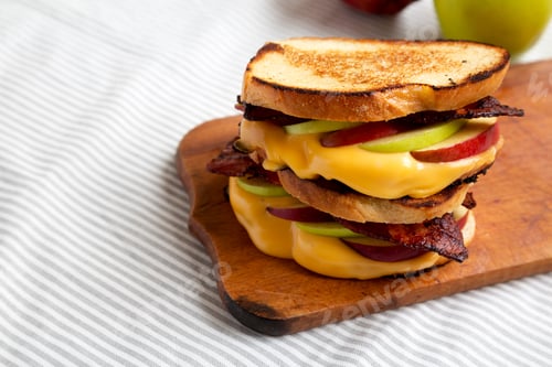 Preview: Homemade Bacon Apple Grilled Cheese On A Rustic Wooden Board, Low Angle View. Copy Space.