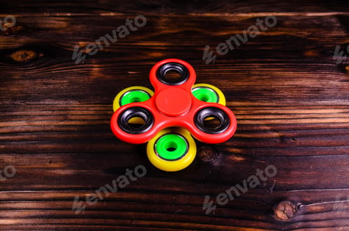 Preview: Yellow And Red Fidget Spinners On Rustic Wooden Desk